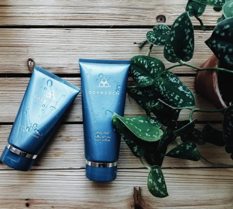 The COSMEDIX Polish body scrub next to a plant