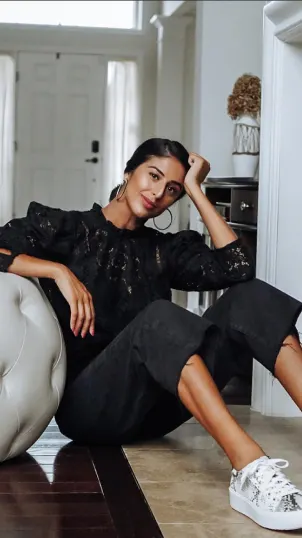 Influencer poses sitting down in black athleisure