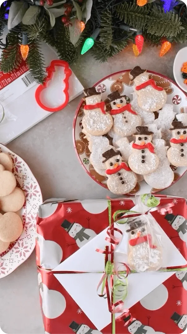 Instagram post with a wrapped gift and American Greetings card next to a plate of snowman cookies