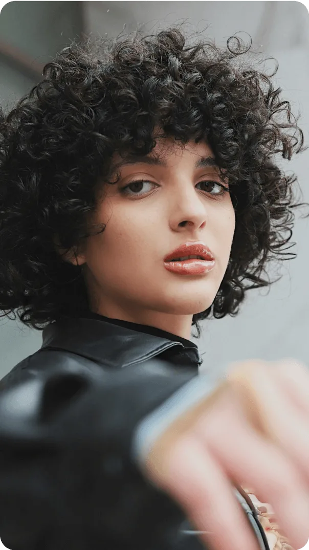 Curly haired influencer stares directly into the camera
