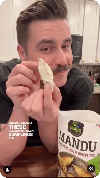 Creator with mustache poses with bibigo Mandu bulgogi chicken dumplings
