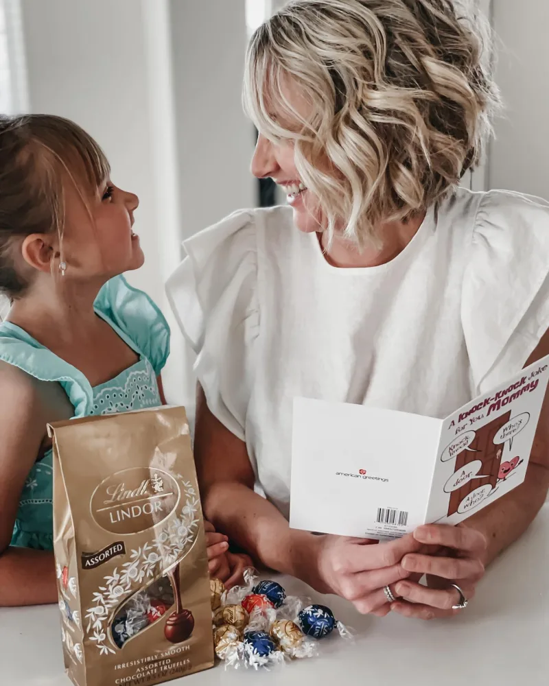 Woman laughs while reading card with her child