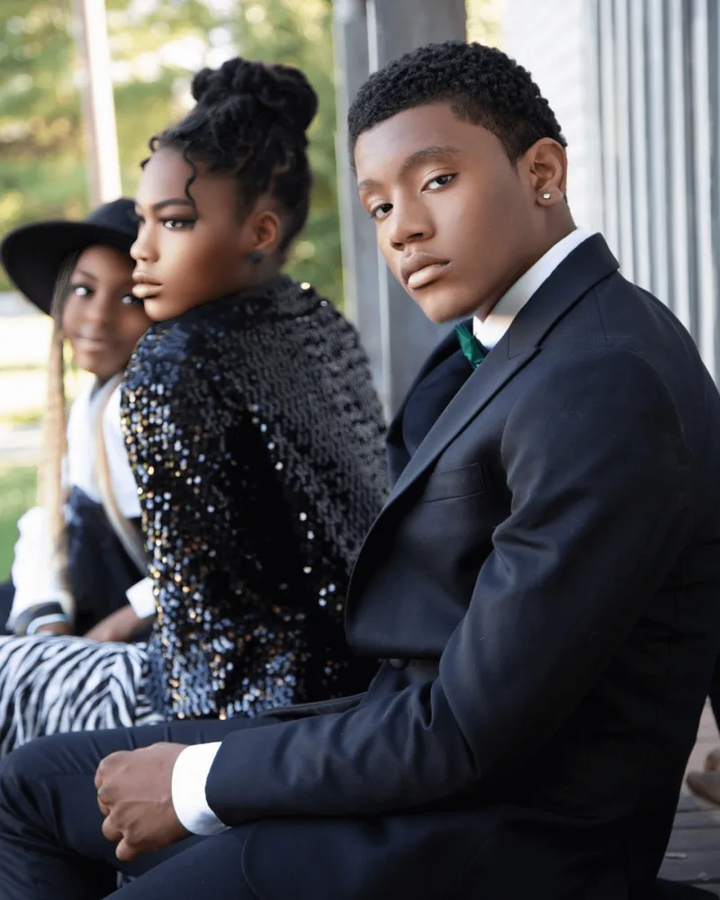 Instagram post of a young man in a black tuxedo and a young woman in a glittery black dress