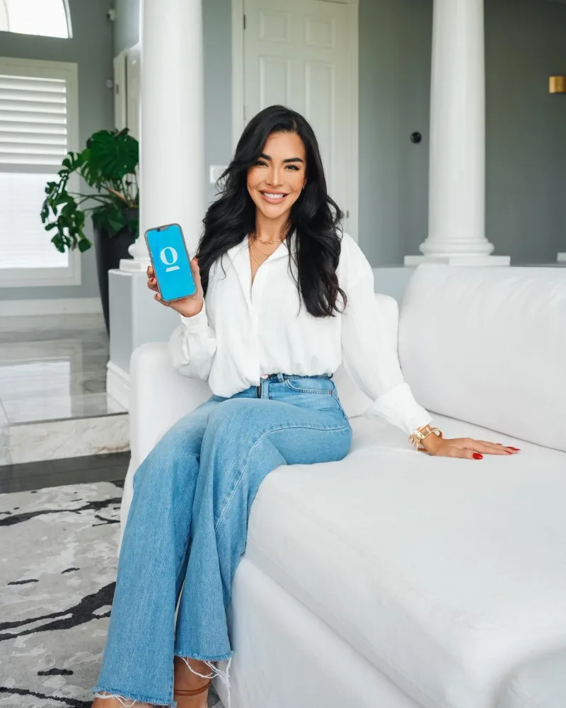 Creator reclines on white couch while using OpenDoor on her phone