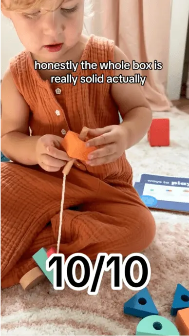 Still from social post with child happily playing with PandaCrate and text overlay rating the box 10 out of 10