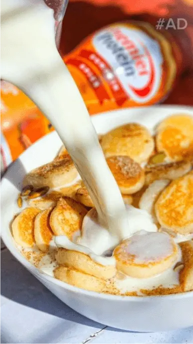 Pumpkin spice protein shake is poured over small pancakes with premier protein bottle in background